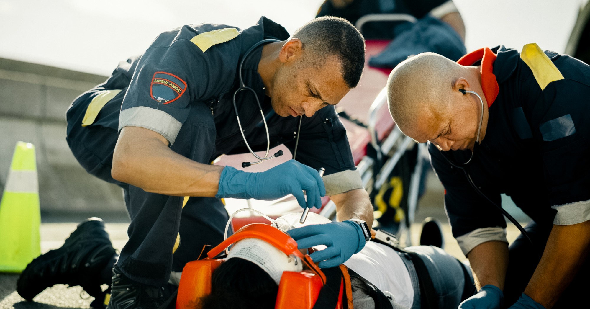 Two paramedics treating a patient on a backboard (stock photo, posed by models)